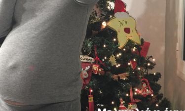 Ποζάρει με φουσκωμένη κοιλίτσα μπροστά στο χριστουγεννιάτικο δέντρο της